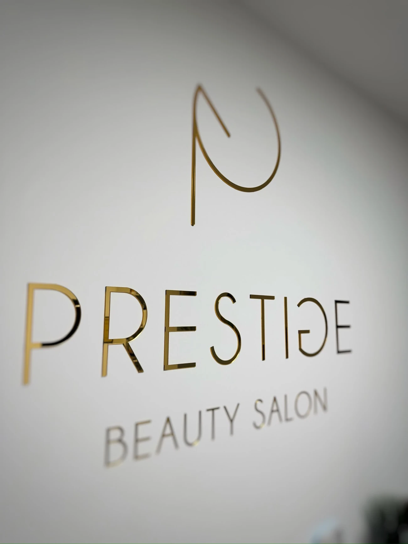 Sigla aurie Prestige Beauty Salon pe peretele salonului din Suceava